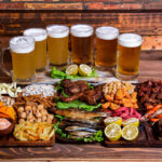 perfect pairings illustrated by a lot of glasses of alcohol of a with a range on appetizers on a table