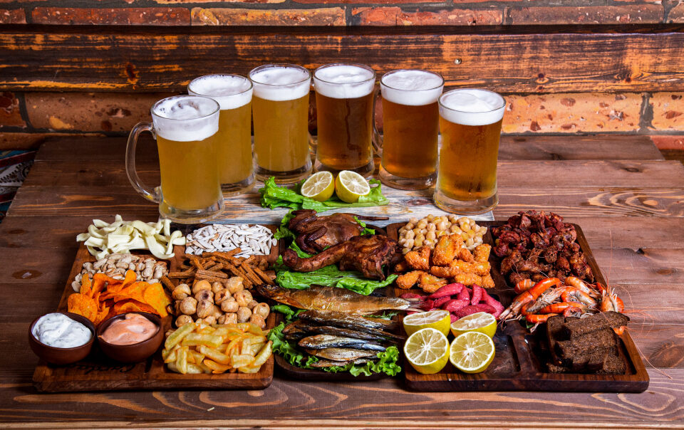 perfect pairings illustrated by a lot of glasses of alcohol of a with a range on appetizers on a table