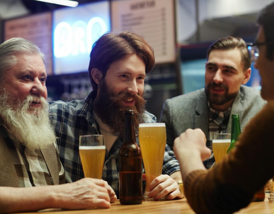 raise a glass with a group of men at a bar holding beer glasses
