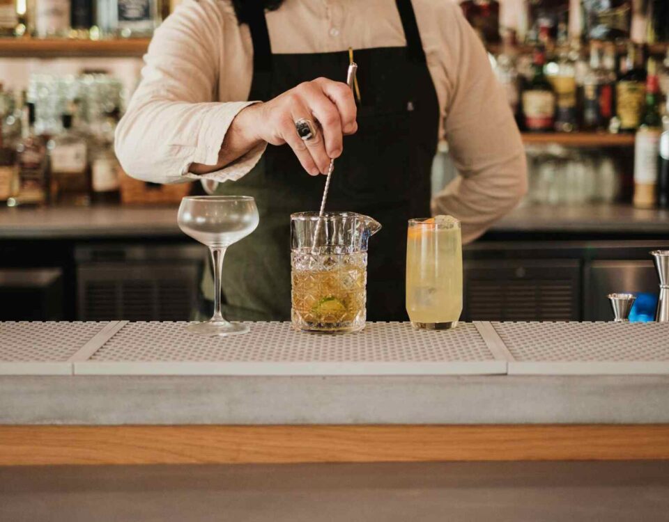 bartender making cocktails at the bar illustrating a clear spirits guide