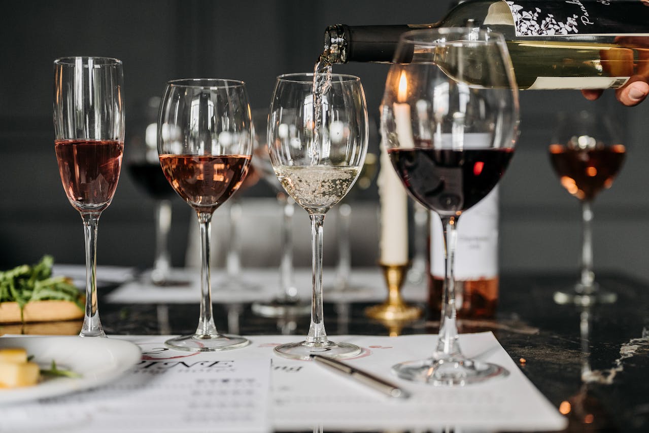 a beginners guide to wine tasting illustrated by a table with wine glasses and note paper