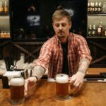 bartender handing out beers behind bar to illustrate pub myths about beer styles