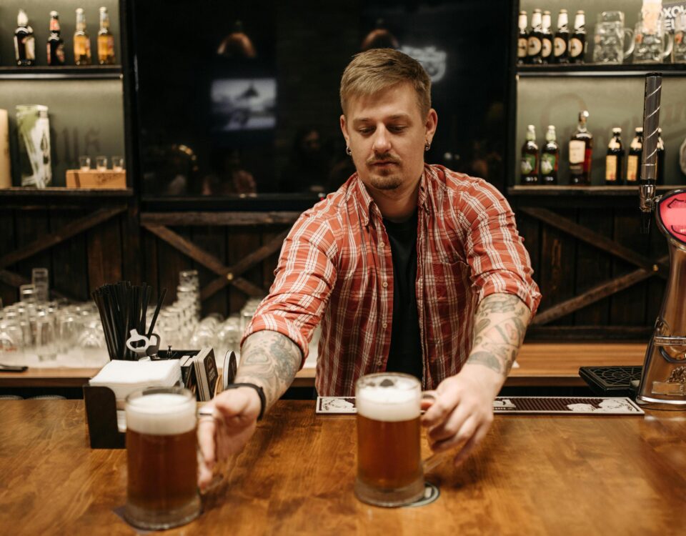bartender handing out beers behind bar to illustrate pub myths about beer styles