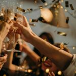 South African Cap Classique celebration with glasses clicking and gold confetti