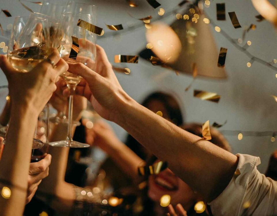 South African Cap Classique celebration with glasses clicking and gold confetti