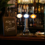 specials chalkboard at bar illustrating Budget-Friendly Bar Hacks