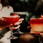 hands holding different easter weekend drinks in dark setting