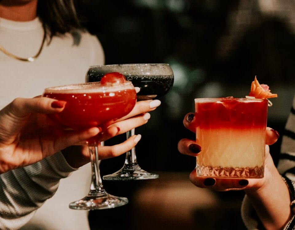 hands holding different easter weekend drinks in dark setting