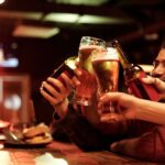 Friends enjoying match-day food pairings with drinks while watching rugby at a local pub.