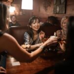 People seated in a corner booth enjoying food, drinks, and conversation in a welcoming pub setting