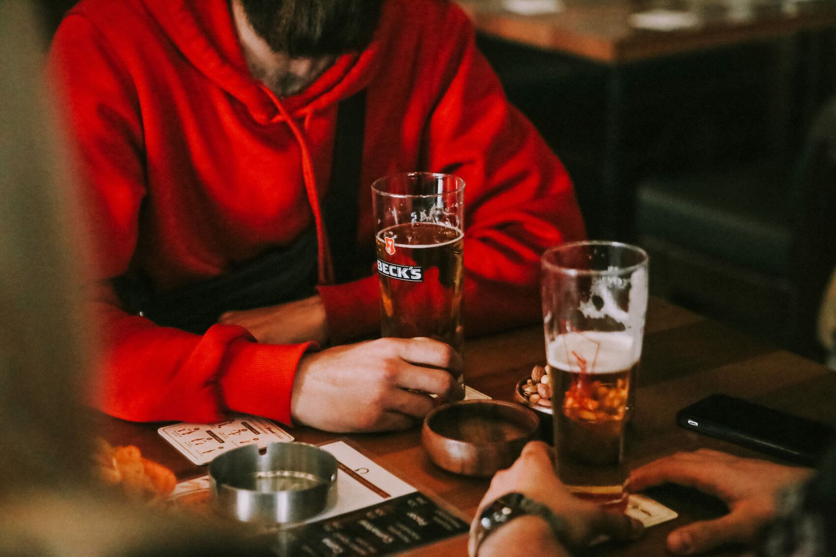People enjoying drinks and conversation in a warm local pub with a relaxed atmosphere and familiar surroundings.