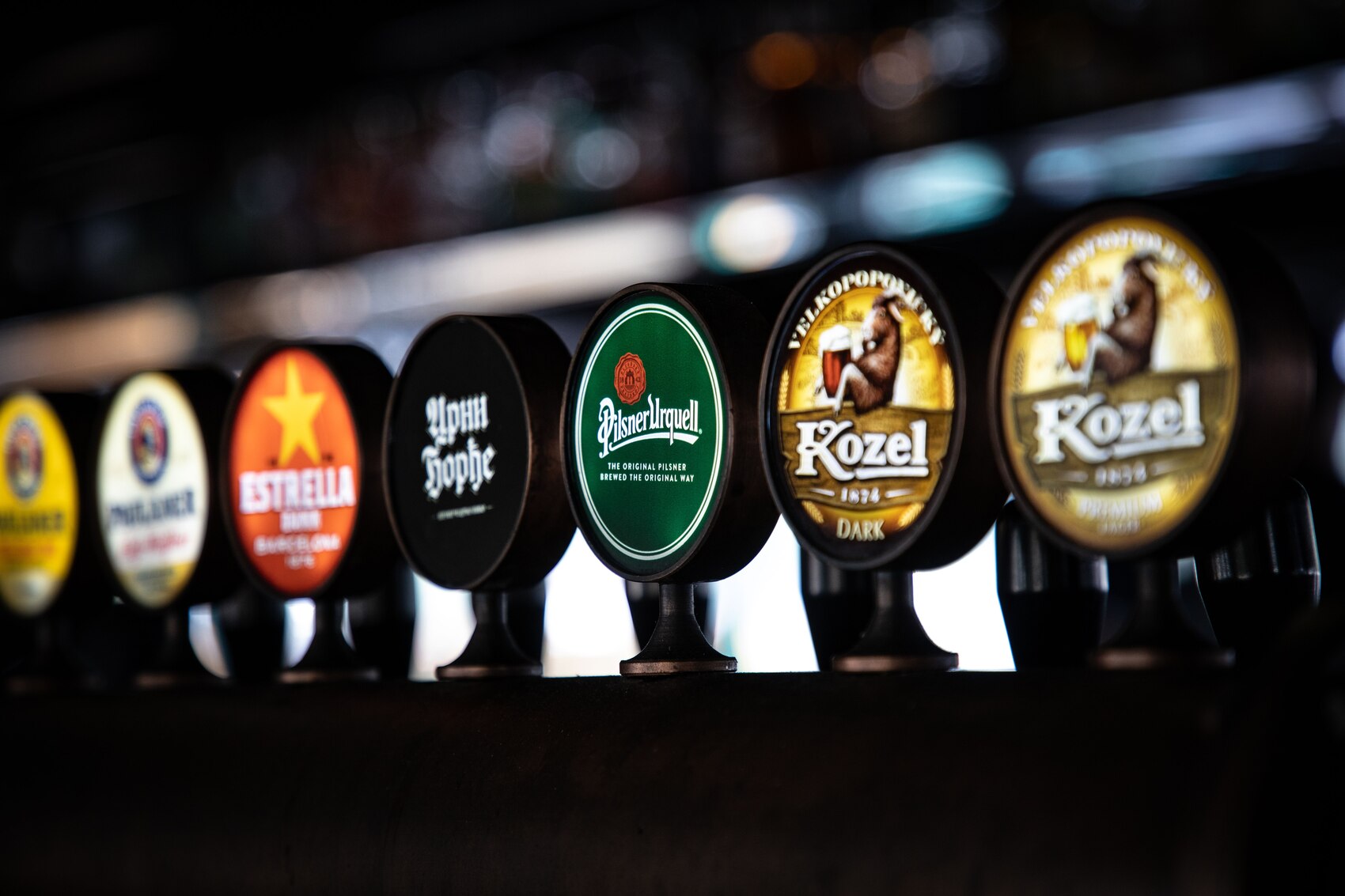 Traditional wooden bar counter with modern draught beer taps at The Highway Pub